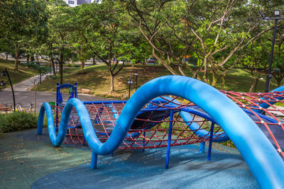 Empty playground against trees in park