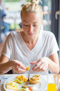 Beautiful woman eating food at restaurant