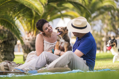 Couple sitting with dog at park
