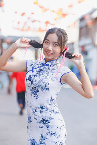 Portrait of smiling teenager girl holding braids