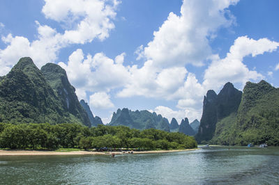 Scenic view of sea and mountains against sky