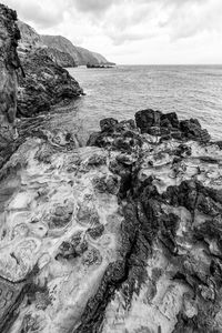 Scenic view of rocks in sea against sky