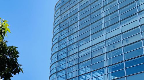 Low angle view of modern building against blue sky