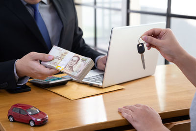 Midsection of woman using mobile phone on table