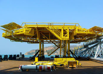 Crane at construction site against clear blue sky