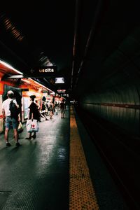 People in illuminated underground walkway