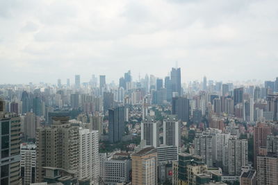 Aerial view of buildings in city against sky