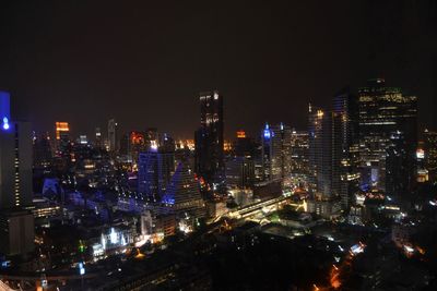 Illuminated cityscape against sky at night