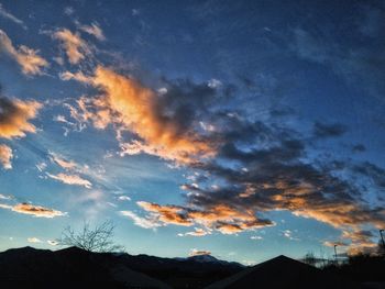 Low angle view of silhouette mountain against dramatic sky