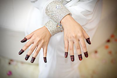 Midsection of woman showing henna tattoo on fingers