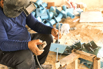 Man welding metal at workshop