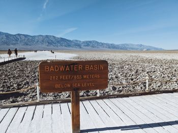 Information sign by mountain against sky