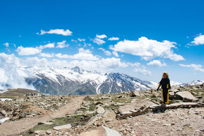 Rear view of woman walking on mountain against sky