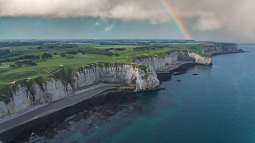 Scenic view of rainbow over sea against sky