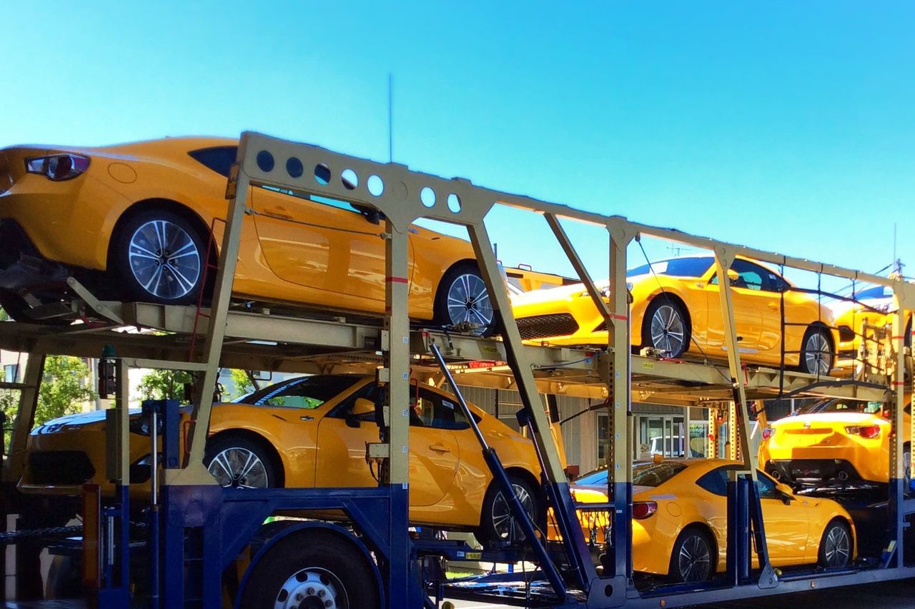 transportation, mode of transport, land vehicle, yellow, car, stationary, travel, street, parked, parking, outdoors, public transportation, no people, day, motorcycle, traffic, on the move, bus, clear sky, metal