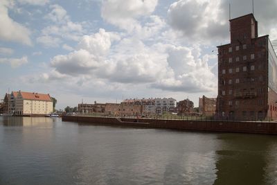 Buildings in city against cloudy sky