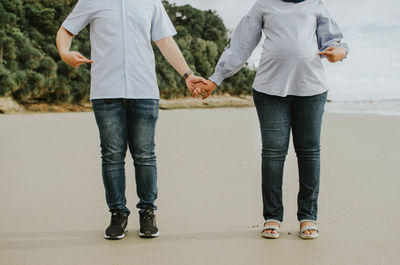 Low section of couple standing outdoors