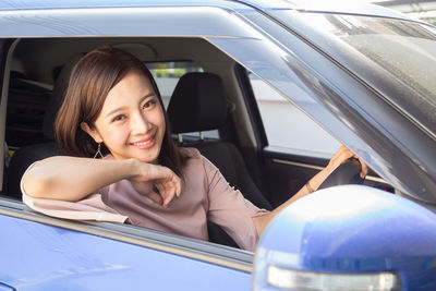 Portrait of smiling woman sitting in car