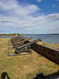 Old ruin on field by sea against sky