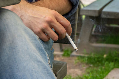 Midsection of man smoking cigarette