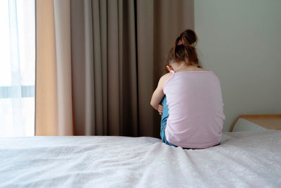 Rear view of woman on bed