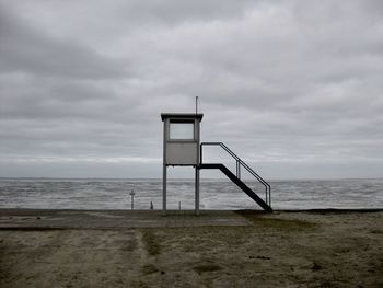 Lifeguard hut on beach against sky