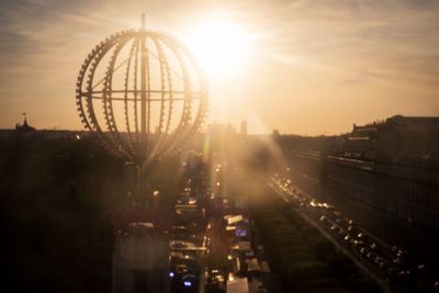 High angle view of ferris wheel against sky during sunset