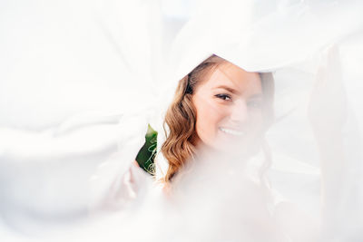 Portrait of smiling young woman holding white