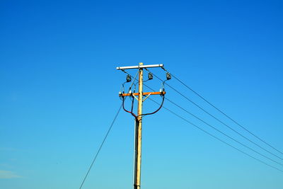 High section of electric pylon against blue sky