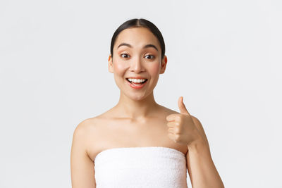 Portrait of a smiling young woman against white background