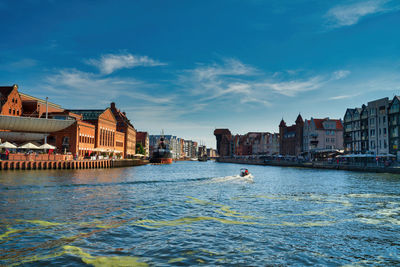 River by buildings against sky in city