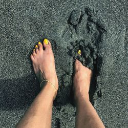 Low section of woman standing at beach