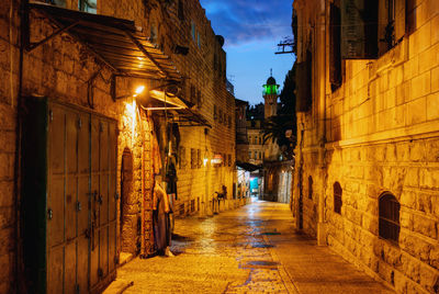 Narrow alley along buildings at night