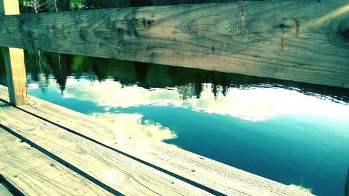 Reflection of wooden pier in water