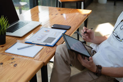 Low angle view of man using laptop on table