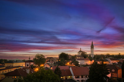 Illuminated buildings against sky at sunset