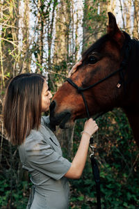 Woman with horse in forest