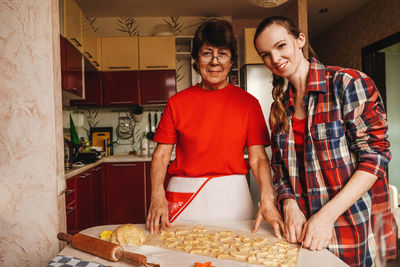 Cheerful mother and daughter making cookies at home