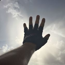Low angle view of man hand against sky