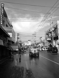 Cars on road against sky in city