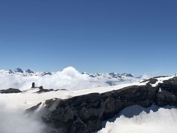 Scenic view of snowcapped mountains against clear blue sky