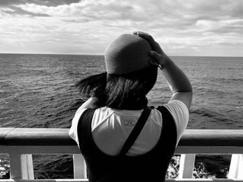 Rear view of woman looking at sea against sky