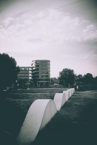 Road by buildings in city against sky