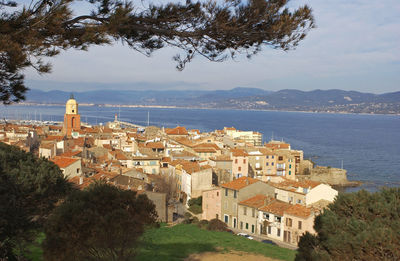 High angle view of townscape by sea against sky