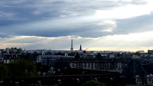 View of cityscape against cloudy sky