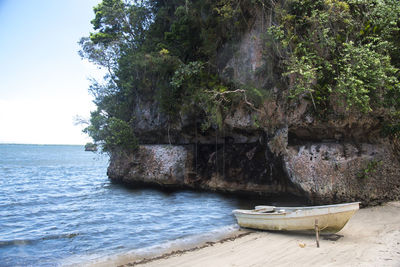 Scenic view of rocks by sea against sky