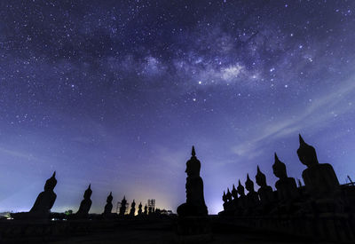 Silhouette temple against sky at night