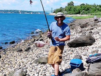 Full length portrait of smiling man on rock