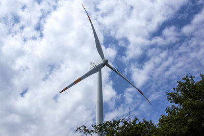 Wind turbine with blue sky and clouds in the background