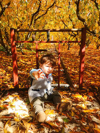 Full length of boy on leaves during autumn